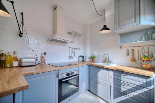 une cuisine avec des armoires bleues et un comptoir dans l'établissement IMMOGROOM - Splendid Terrace - Studio - Central, à Cannes