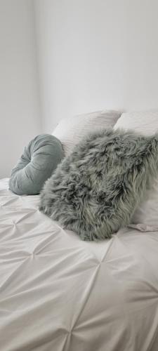 a furry blanket on a bed with pillows at Le P'tit Bohème, Terrasse privative. in Lanester