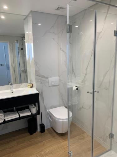 a bathroom with a shower and a toilet and a sink at Hotel Abbaye du Golf de Lésigny in Lésigny