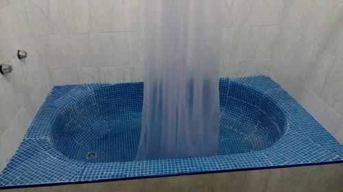 eine Dusche mit blauer Badewanne im Bad in der Unterkunft Hotel San Carlos Yautepec in Yautepec de Zaragoza