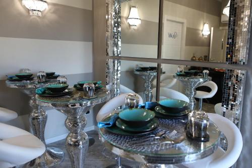a table with plates and dishes on a table with a mirror at B&B Bellavista Exclusive in zona centrale con piscina riscaldata e Jacuzzi vista lago LA COLAZIONE viene servita in una pasticceria rinomata ed esclusiva esterna alla struttura in Desenzano del Garda
