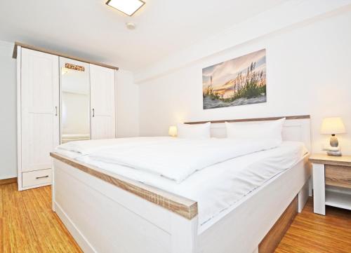 バンシンにあるApartment Strandgutの白いベッドルーム(大きな白いベッド1台付)