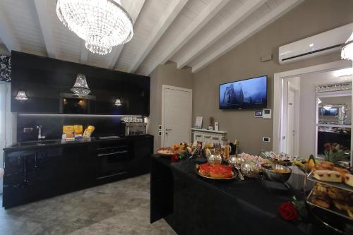 a large kitchen with a table with food on it at B&B Bellavista Exclusive in zona centrale con piscina riscaldata e Jacuzzi vista lago LA COLAZIONE viene servita in una pasticceria rinomata ed esclusiva esterna alla struttura in Desenzano del Garda