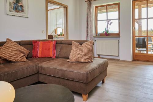 a living room with a brown couch with colorful pillows at Ferienwohnung Patermann in Pommelsbrunn