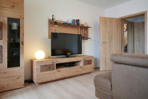 uma sala de estar com televisão num centro de entretenimento em madeira em Ferienwohnung Patermann em Pommelsbrunn