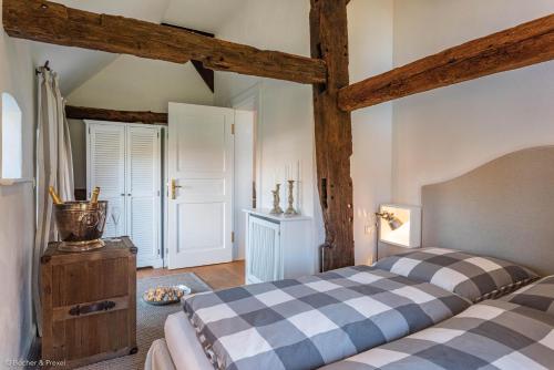 a bedroom with a bed with a checkered bedspread at HofGut Bockelkathen Apartment 5 in Lüdersburg