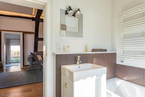 a bathroom with a sink and a bath tub at HofGut Bockelkathen Apartment 5 in Lüdersburg