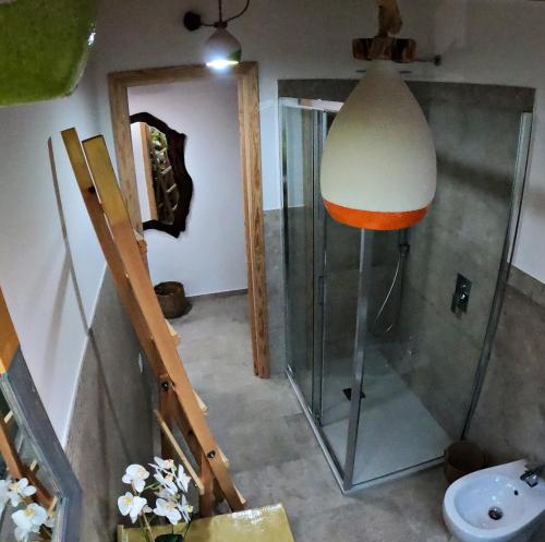 a bathroom with a shower and a lamp and a toilet at B&B Les Chambres Rooms & Suite in Santa Teresa Gallura