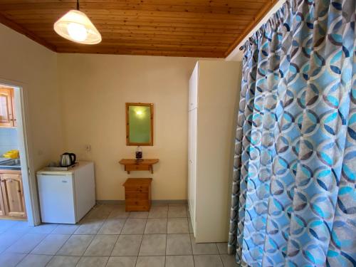 a room with a kitchen and a shower curtain at MARATHES STUDIOS in Agios Nikitas
