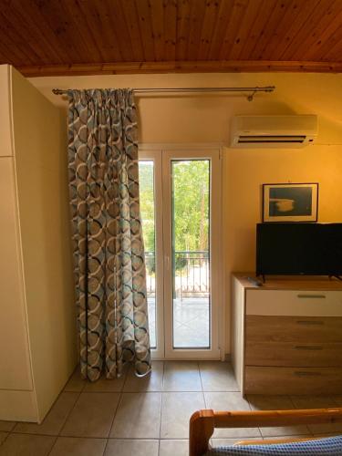 a living room with a sliding glass door at MARATHES STUDIOS in Agios Nikitas