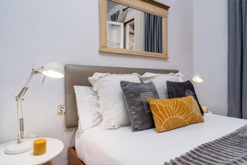 1 dormitorio con cama con almohadas y espejo en Whisper-quiet Near Sagrada's Heart, en Barcelona