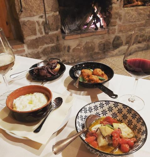 a table with plates of food and glasses of wine at Al Vecchio Corso B&B in Tempio Pausania