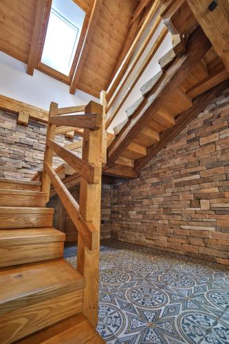 an attic room with wooden stairs and a window at Roubenka U Zvoničky in Cejle