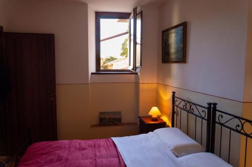 a bedroom with a bed and a window at Il Vicolo de Ascesi in Assisi
