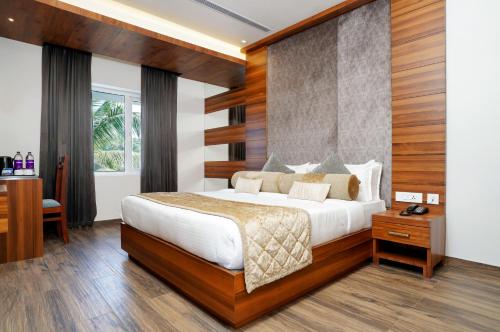 a bedroom with a large bed and a desk at Nexstay River Mouth International in Ferokh