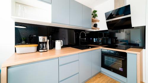 a kitchen with white cabinets and a wooden counter top at Domki Sikorskiego II, Sun & Snow in Karpacz