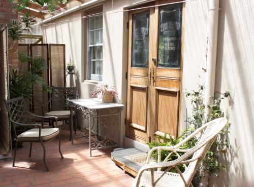 a patio with chairs and a table and a door at Werndee in Hobart