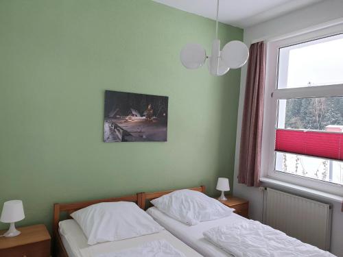 ブライテンブルンにあるErzgebirgsidyll Breitenbrunn Ferienwohnungのベッドルーム1室(ベッド2台、窓付)