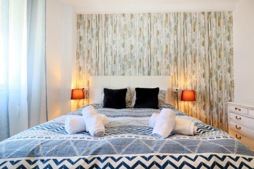 a bedroom with a large bed with two pillows at NEW Apartamento Tierra Andaluza junto Mezquita in Córdoba