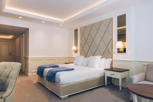 a hotel room with a bed and a chair at Heritage Grand Perast By Rixos in Perast