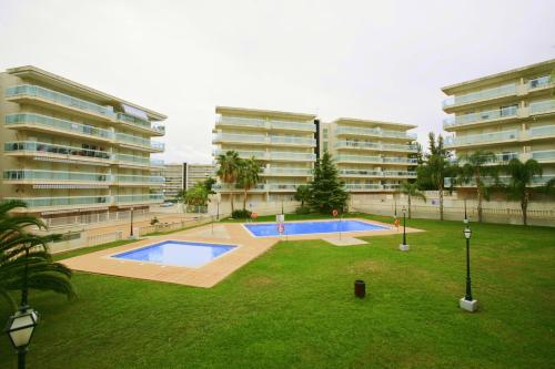 an apartment complex with a swimming pool in a yard at APCOSTAS - Village Park in Salou