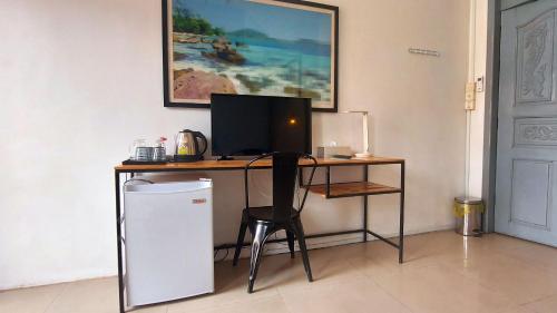 a desk with a computer and a chair in a room at THE PLACE Hostel Battambang in Battambang
