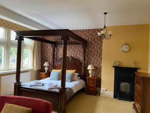 a bedroom with a canopy bed and a fireplace at Barringtons in Matlock