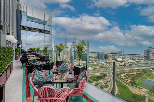 a balcony with tables and chairs and a view of a city at Taj Jumeirah Lakes Towers in Dubai