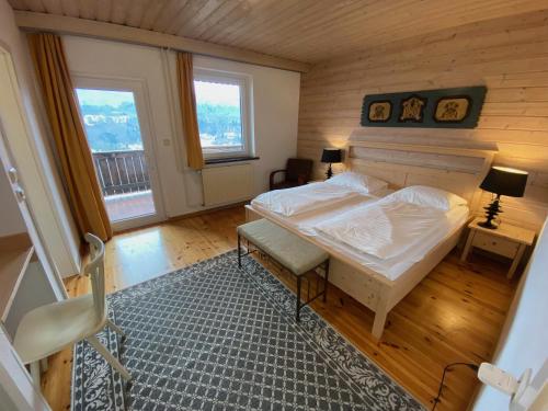a bedroom with a large bed and two windows at Kunstelj Pension in Radovljica