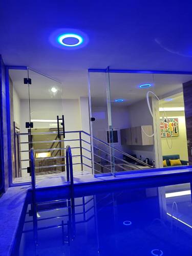 a swimming pool with two chairs in a room at RAWND Hotel Apartments in Dammam