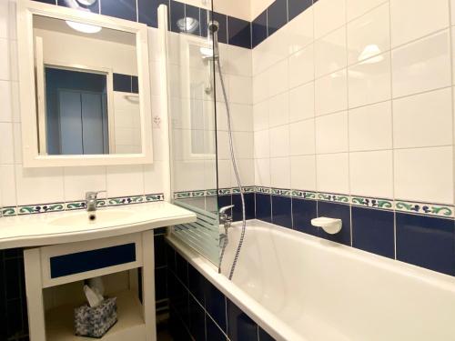 une salle de bain avec une baignoire, un lavabo et un miroir dans l'établissement REF 057 - Appartement pour quatre personnes avec terrasse secteur port Crouesty ARZON, à Arzon