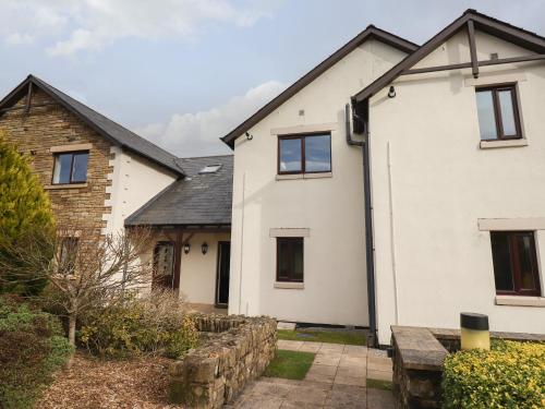 a white house with a stone wall at Tilly Mint Cottage in Penrith