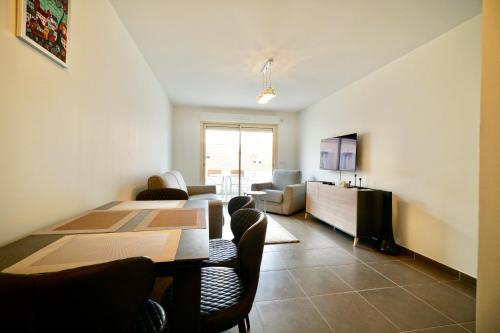 a dining room with a table and chairs and a living room at Apartment Montaigne in Cannes