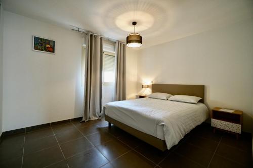 a bedroom with a large bed and a window at Apartment Montaigne in Cannes