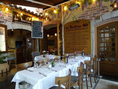 - une table dans un restaurant avec des tables et des chaises blanches dans l'établissement Apartment Rue St Antoine, à Cannes