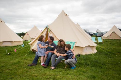 a group of people sitting in front of tents at Glamping at Hay Festival in Hay-on-Wye