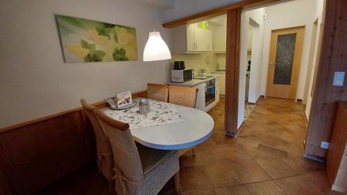 a kitchen with a table and chairs and a kitchen with a counter at Landhaus Schlossberg in Medebach