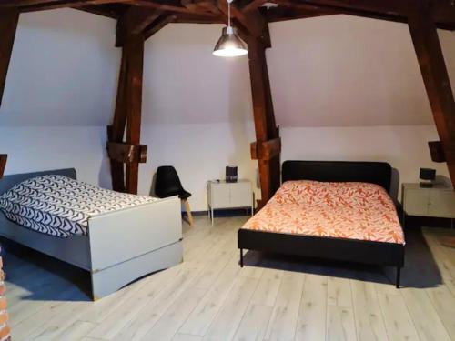 Duas camas num quarto com pisos em madeira em Appartement d'une chambre avec wifi a Beaugency em Beaugency