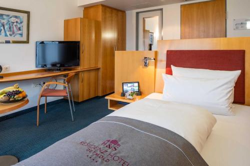 a hotel room with a bed and a tv at Residenz Hotel Detmold in Detmold