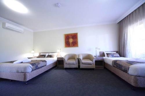 a hotel room with two beds and a couch at Gundagai Gabriel Motor Inn in Gundagai