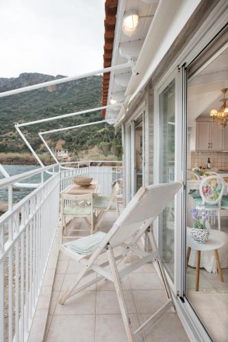 a balcony with a chair and a table at Dream House Efi in Ravdhoúkha