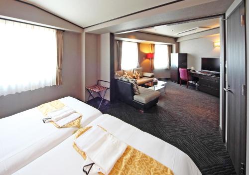 a hotel room with a large bed and a living room at Hotel Sun Plaza Sakai Annex in Sakai