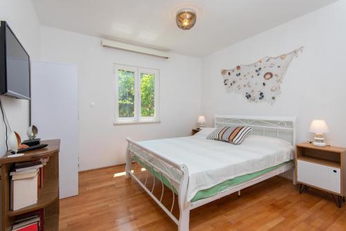 a bedroom with a bed and a flat screen tv at Little House Orebić in Orebić