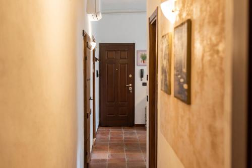 a hallway with a brown door and a tile floor at Conce Apartment in Pisa