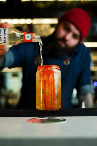 a man is pouring a bottle into a candle at Dublin One in Dublin