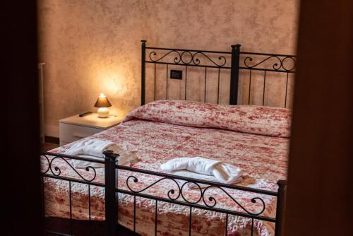 ein Schlafzimmer mit einem Bett und einem Nachttisch mit einer Lampe in der Unterkunft Conce Apartment in Pisa