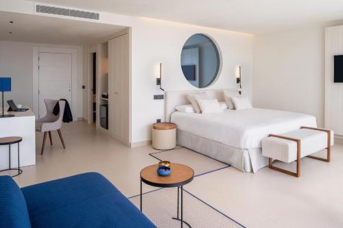 Habitación de hotel con cama y sala de estar. en Royal Marina Suites Boutique Hotel, en Puerto Calero