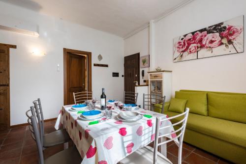 a dining room with a table and a green couch at Conce Apartment in Pisa