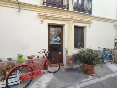 uma bicicleta vermelha estacionada em frente a um edifício em Sa Ferula em Tortolì