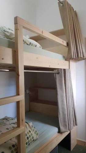 a wooden bunk bed in a room with a curtain at Heart of Glencoe Holidays in Glencoe